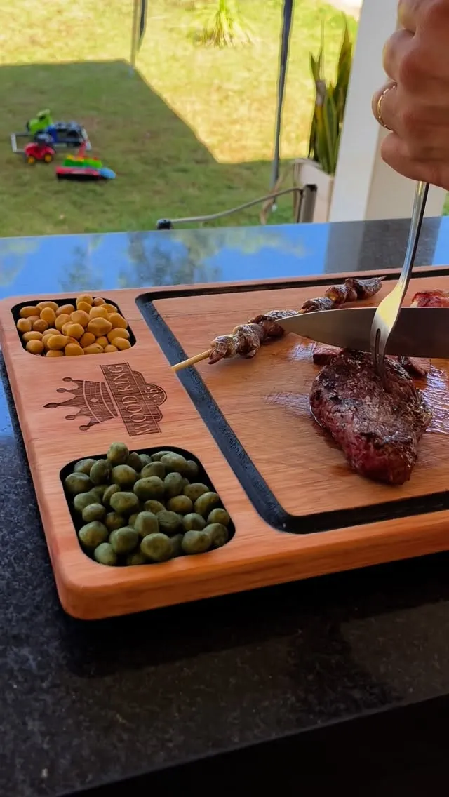 Bife e espetinho cortados na tábua de teca