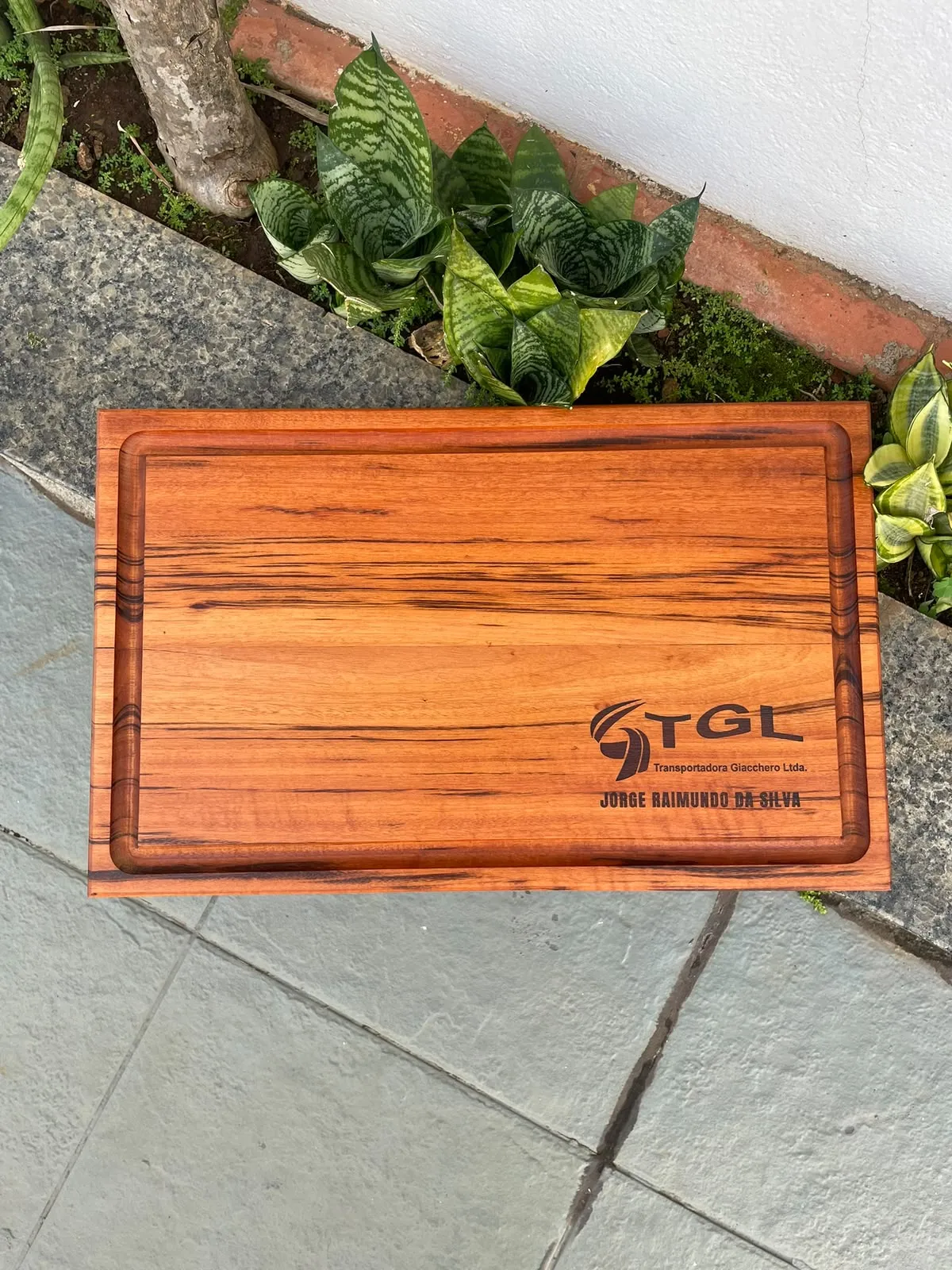 Tábua de muiracatiara com o logo da TGL Transportadora gravado